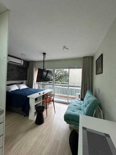 a bedroom with a bed and a desk and a couch at Nari Loft in São Paulo