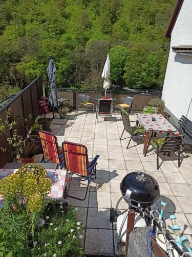 a patio with chairs and a table and a grill at Ferienwohnung mit Terrasse für 1-4 Personen in Altena