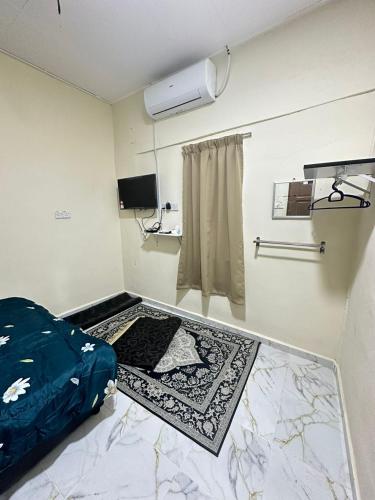 a room with a bed and a suitcase on the floor at Teratak Cikgu Roomstay 2 in Kampong Tok Barat