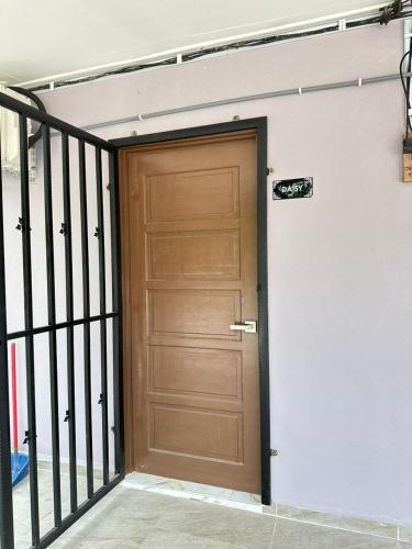 a wooden door on a building with a gate at Teratak Cikgu Roomstay 2 in Kampong Tok Barat