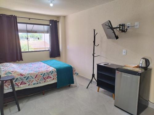 a bedroom with a bed and a desk and a window at Casa de Praia Família Próximo ao ExpoCentro BC in Balneário Camboriú
