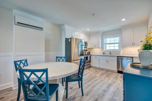 a kitchen with a table and blue chairs at Adjacent 2nd Floor, 2004 Queen & 2005 Queen in Surf City