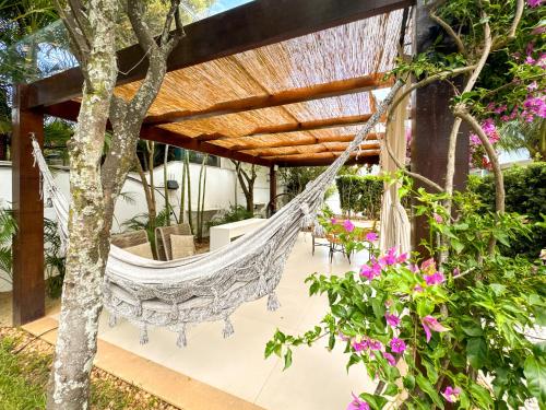 a hammock on the patio of a house at Hotel Boutique Recanto da Passagem in Cabo Frio
