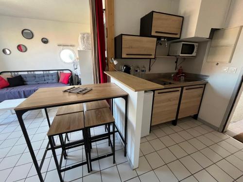 une cuisine et un salon avec une table et un évier dans l'établissement Studio mimizan plage, à Mimizan-Plage