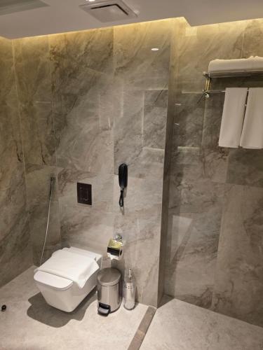 a bathroom with a toilet and a shower at Sedra Global Hotel, Madinah - فندق سدرة العالمى, المدينة in Al Madinah