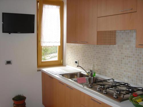 a kitchen with a sink and a stove and a window at 03 Virgilio Zanetti in San Zeno di Montagna