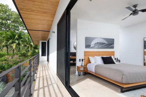 サンタ・テレサにあるVilla Nof Yam - Luxury Ocean View, Santa Teresaのベッドとバルコニーのある寝室