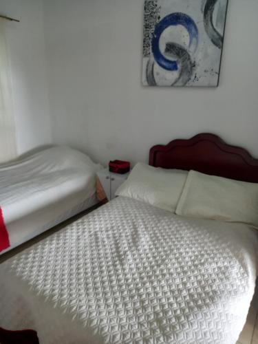 a bed in a bedroom with a white bedspread at EL Refugio in La Vega