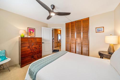 a bedroom with a bed and a ceiling fan at Stunning ocean view 2 bedroom Steps from beach in Kihei