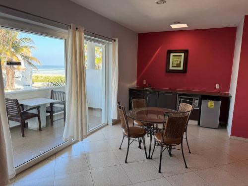 een eetkamer met een tafel en uitzicht op de oceaan bij HOTEL CARASOL VILLAS & SUITES in Ciudad Madero