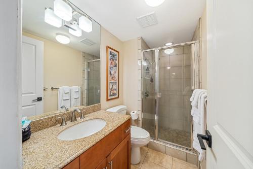 a bathroom with a sink and a shower and a toilet at Stunning ocean view 2 bedroom Steps from beach in Kihei