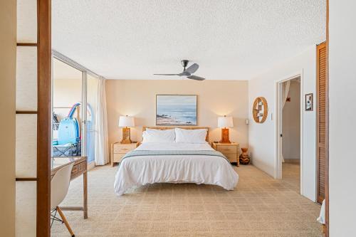 a bedroom with a bed and a desk and a window at Stunning ocean view 2 bedroom Steps from beach in Kihei