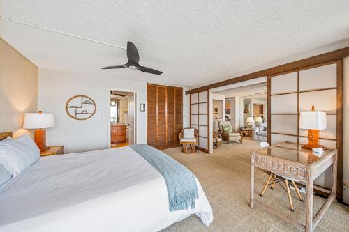 a bedroom with a large bed and a table at Stunning ocean view 2 bedroom Steps from beach in Kihei