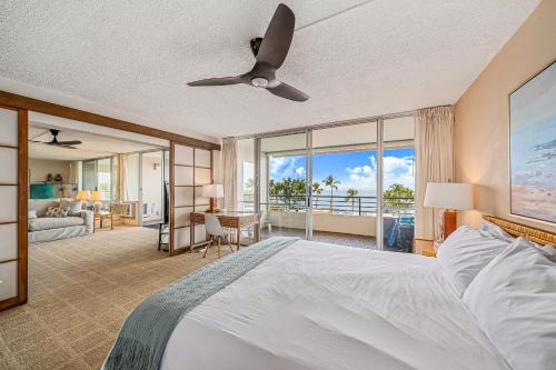 a bedroom with a large bed with a ceiling fan at Stunning ocean view 2 bedroom Steps from beach in Kihei