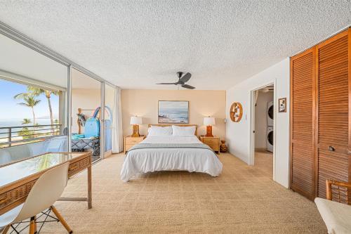 a bedroom with a bed and a view of the ocean at Stunning ocean view 2 bedroom Steps from beach in Kihei