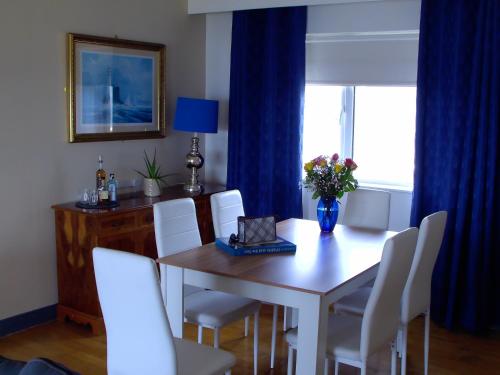 a dining room table with white chairs and a vase of flowers at Dolphin Watch in Fanore
