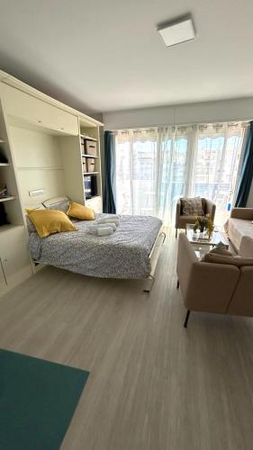 une chambre avec un lit et un salon avec un canapé dans l'établissement Bright & Spacious Studio near La Croisette, à Cannes