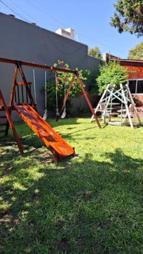 an orange swing set in a yard with grass at Hotel Mayoral in Rosario