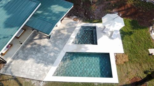 an overhead view of two swimming pools on a house at Pandanus Lodge & Retreats Bungalow Orchidee in San Ramón