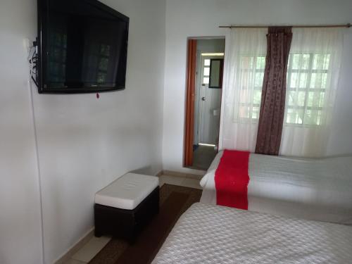 a small bedroom with two beds and a tv at EL Refugio in La Vega