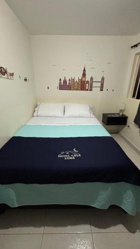 a bedroom with a large bed with a blue blanket at Hotel Casa Luna in Bogotá