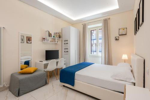 a white bedroom with a bed and a desk at Maison38GuestHouse in Castellammare di Stabia