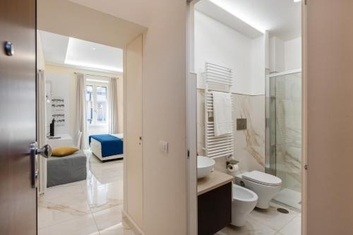 a white bathroom with a toilet and a sink at Maison38GuestHouse in Castellammare di Stabia