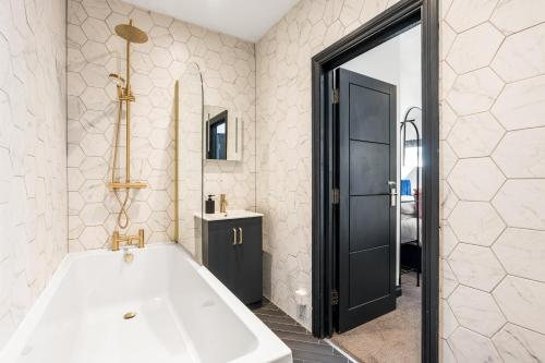 a bathroom with a white tub and a mirror at Western Seaview Terrace - Central - Contractors in Brighton & Hove