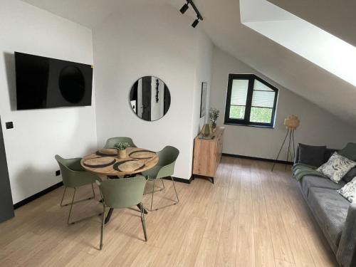 a living room with a table and a couch at Harmony House -Appartement Green in Kołczewo