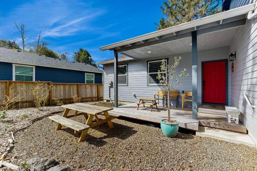 a patio with a picnic table and a red door at Sol Retreat in Rockaway Beach