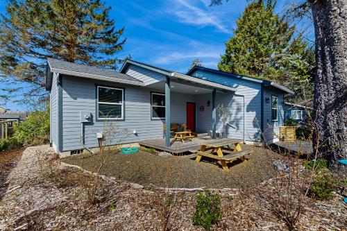 a blue tiny house with a picnic table and a picnic bench at Sol Retreat in Rockaway Beach