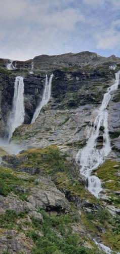 two waterfalls on the side of a rocky mountain at Over the Fjord in Leikanger