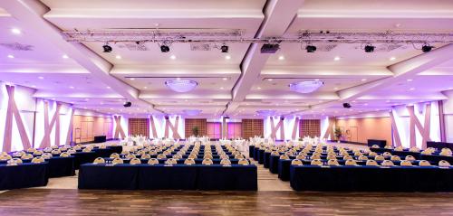 a large room with rows of tables and chairs at Wyndham Grand Salzburg Conference Centre in Salzburg