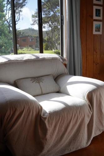 a white couch sitting in front of a window at Okupu Beach House in Okupu