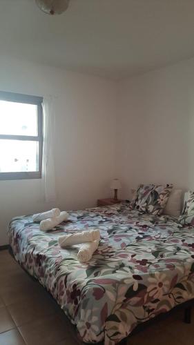 ein Schlafzimmer mit einem Bett mit einer Bettdecke darauf in der Unterkunft Vivienda Amanecer in Los Cancajos