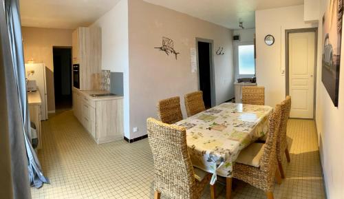 une salle à manger avec une table et des chaises et une cuisine dans l'établissement Maisons de vacances 6 pers proche plan d'eau, à L'Aiguillon-la-Presqu'île