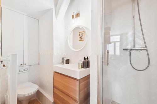 une salle de bain blanche avec un lavabo et une douche dans l'établissement L'Oasis Rouennais - Hypercentre - Gare rive Gauche, à Rouen