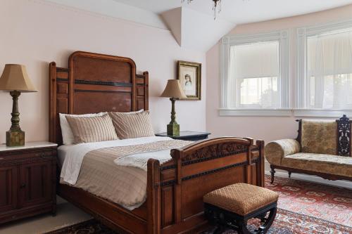 a bedroom with a large wooden bed and a chair at Chateau Tivoli Bed and Breakfast in San Francisco