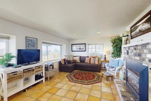a living room with a tv and a couch at Hale Kaalawai Unit B in Oceanside