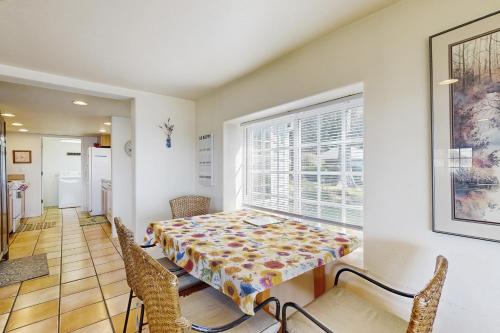a dining room with a table and chairs and a window at Hale Kaalawai Unit B in Oceanside