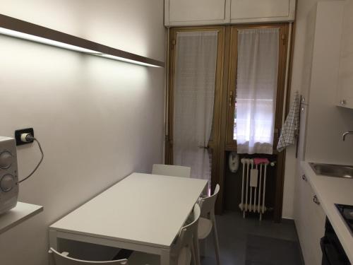 パドヴァにあるAppartamenti Dolly, tre unità distinteの白いテーブルと窓が備わる客室です。