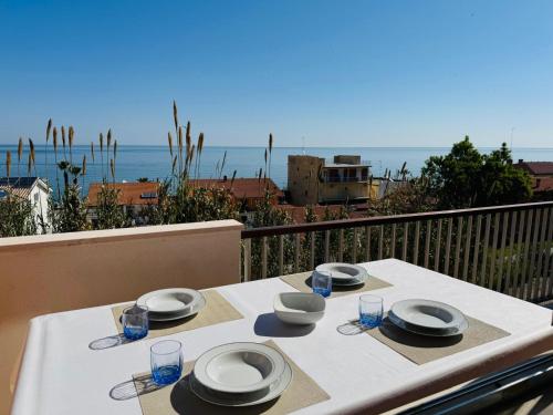 a table with plates and bowls on a balcony with the ocean at La Finestra Sul Mare in Fossacesia