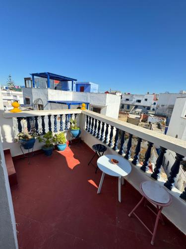 a balcony with chairs and tables on a building at Dar Yema in Asilah
