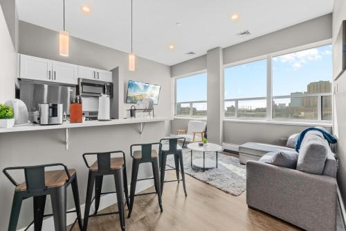 a kitchen and living room with a couch and chairs at Modern 1 Bedroom Apartment with 2 TVs Fast WiFi and Free Parking in Cleveland