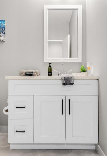 a white bathroom with a sink and a mirror at Modern 1 Bedroom Apartment with 2 TVs Fast WiFi and Free Parking in Cleveland