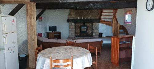 une pièce avec une table, des chaises et une cheminée dans l'établissement Maison confortable à Questembert avec jardin, à Questembert