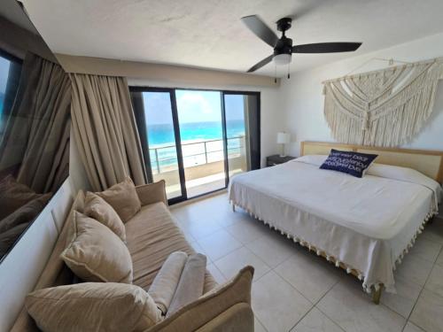 a bedroom with a bed and a couch and the ocean at Perfect vacation getaway,Ocean View,Wifi, Beach in Cancún
