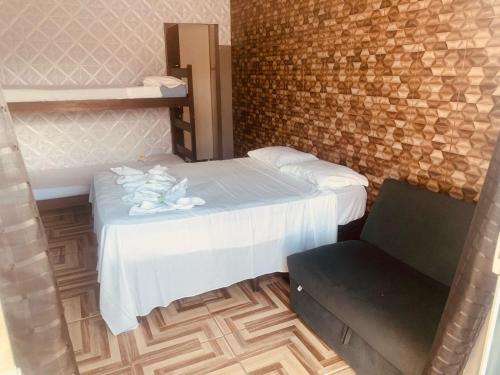 a small room with a bed and a chair at kitnet aconchegante in Ubatuba