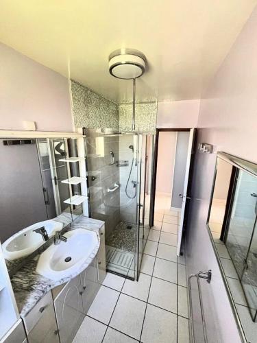 La grande salle de bains est pourvue d'un lavabo et d'une douche. dans l'établissement Maison 3 chambres - Royan, à Royan