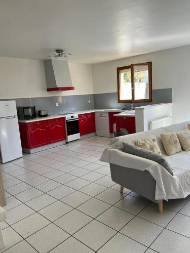 - une cuisine avec des placards rouges et un canapé dans la chambre dans l'établissement Maison 3 chambres - Royan, à Royan